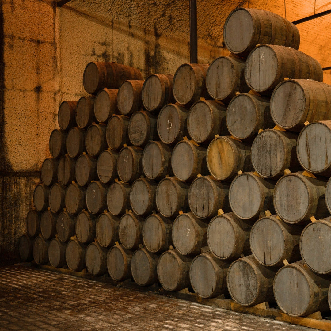 Tequila ageing in a stack of wooden barrels.