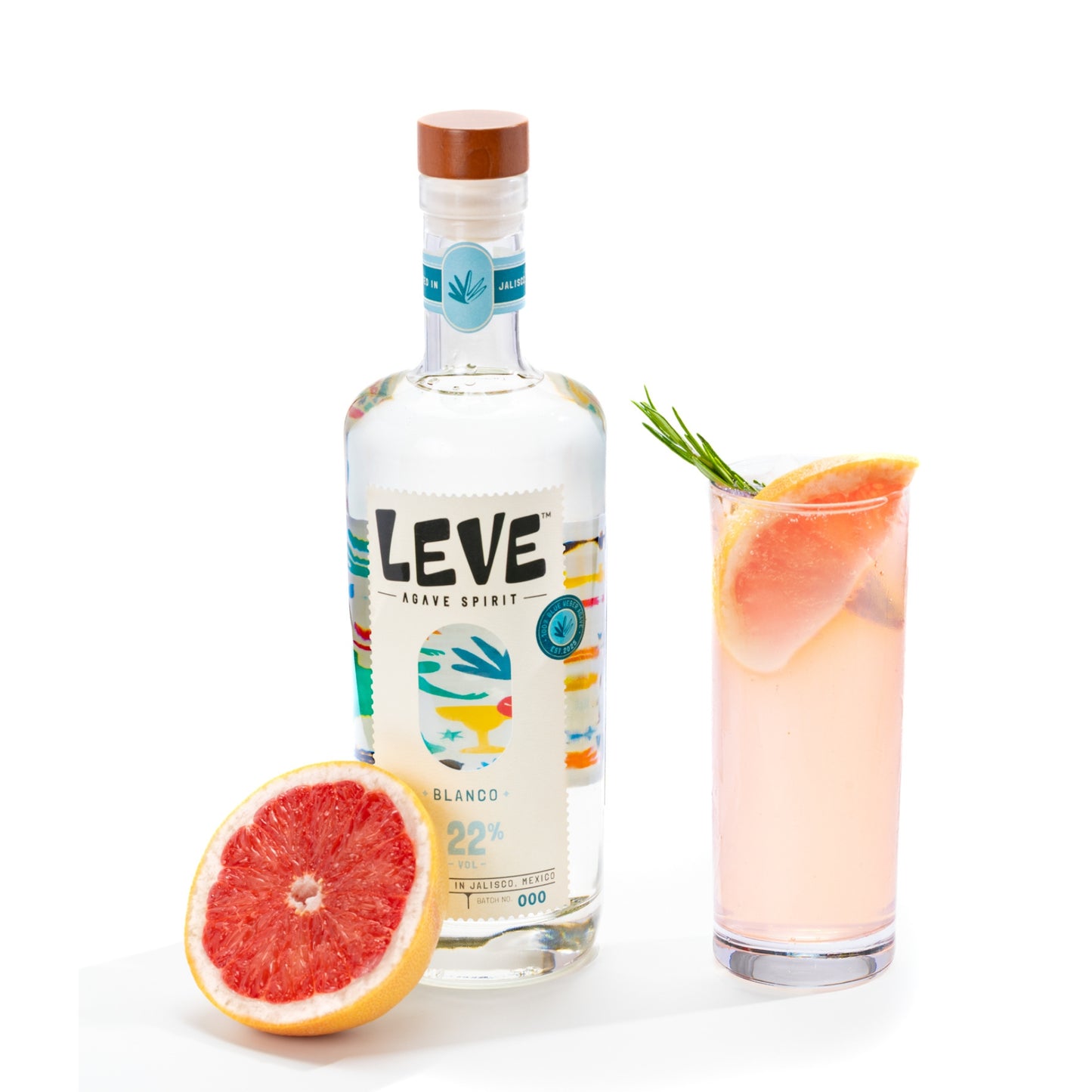 Bottle of Leve Blanco with a paloma cocktail and grapefruit half